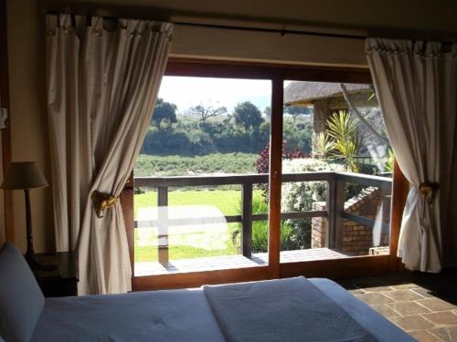 una camera con un letto e una grande finestra di Khandizwe Kruger Villa a Malelane
