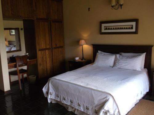 a bedroom with a large bed with white sheets and pillows at Khandizwe Kruger Villa in Malelane