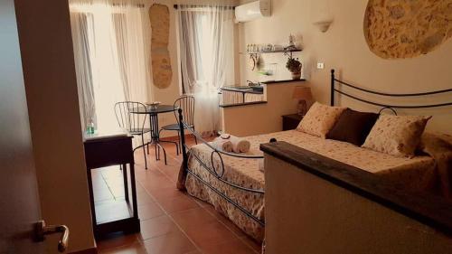 a bedroom with a bed and a table in a room at Perla Del Borgo Appartamenti in Santa Caterina dello Ionio