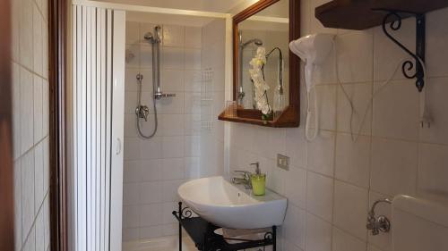 La salle de bains blanche est pourvue d'un lavabo et d'une douche. dans l'établissement Perla Del Borgo Appartamenti, à Santa Caterina dello Ionio