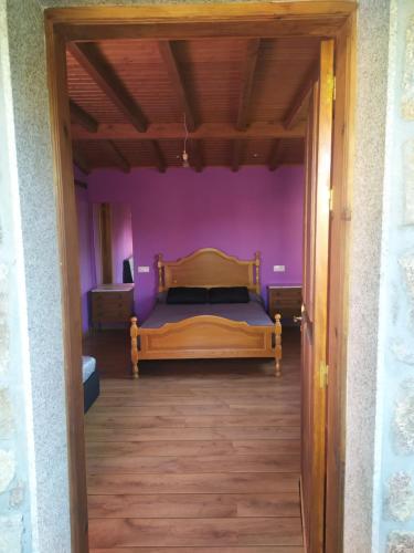 um quarto com uma cama num quarto roxo em CASA "O Campo" em Sober