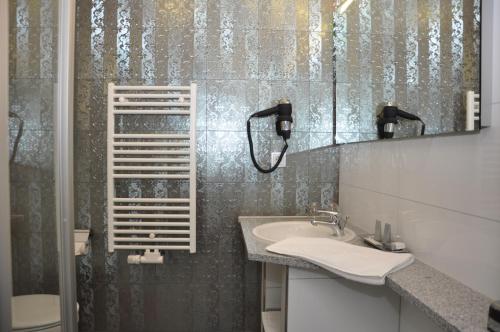 La salle de bains est pourvue d'un lavabo et d'un miroir. dans l'établissement Gästehaus Villa Casamia, à Schmalkalden