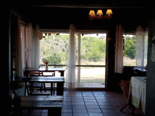 een kamer met een tafel en een groot raam bij La Virazón in Punta Del Diablo