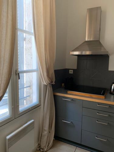 a kitchen with a stove and a window at Apartment Limas in Avignon