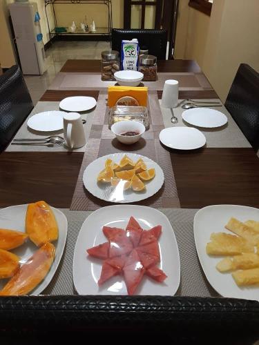 a long table with plates of food on it at Kilimanjaro Country House in Moshi