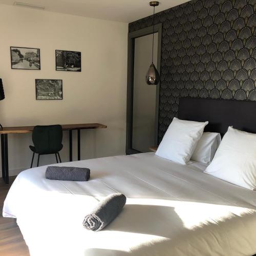 a bedroom with a large white bed and a desk at Casa Santa Lucia in Bocognano