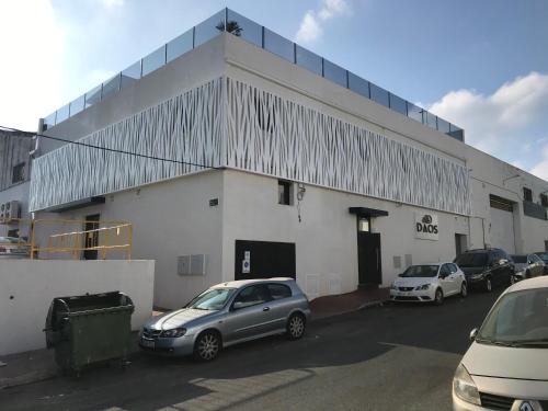 a white building with cars parked in front of it at DAOS Suites & Terrace Marbella in Marbella