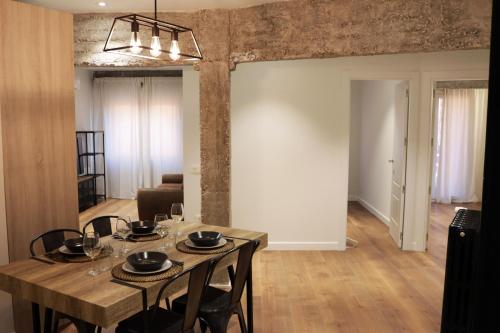 uma sala de jantar com uma mesa de madeira e cadeiras em Ático Industrial Céntrico, Reformado, Air-Acond, Netflix, WiFi em Salamanca