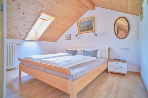 un letto in una camera da letto con soffitto in legno di Supperior Appartement a Rasùn di Sotto