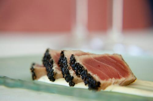 a piece of fish with blackberries on top of it at Serendipity Country House & Restaurant in Wilderness
