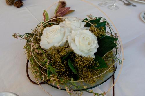 a glass bowl with white roses on a table at Hospedium Hotel Los Lanceros in San Lorenzo de El Escorial