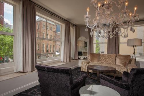 a living room with a chandelier and a couch and a table at International House Hotel in New Orleans