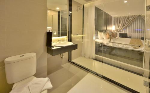 La salle de bains est pourvue de toilettes et d'un lavabo. dans l'établissement Tjokro Hotel Pekanbaru, à Pekanbaru