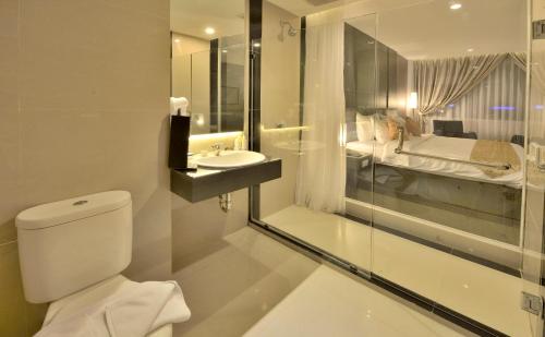 a bathroom with a toilet and a sink at Tjokro Hotel Pekanbaru in Pekanbaru