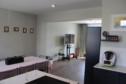 a kitchen and living room with a table and chairs at Revelatio, dé logies in Ypres