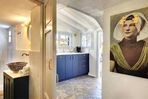 una cocina con una pintura de una mujer en la pared en The Dutch Suite, romantic boutique guesthouse, en Porto Heli