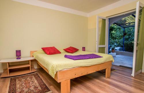 a bedroom with a bed with two red pillows on it at Casa Porozina - Paradise Beach in Cres