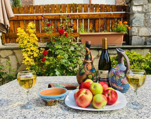 a table with a plate of apples and wine glasses at Hotel Aragvi in Mtskheta