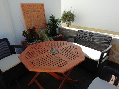 a table and chairs on a balcony with plants at Apartamento Nora in Lagos