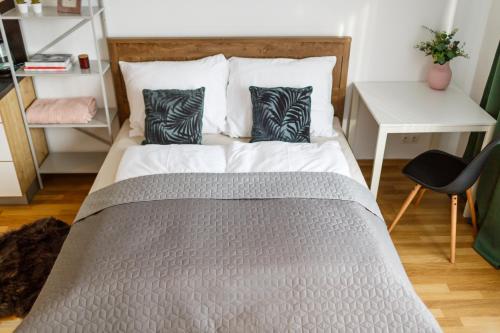 a bed with two pillows on it in a bedroom at Golden Apartments Rezidence Nová Karolina in Ostrava
