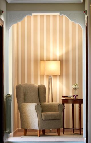 a living room with a chair and a lamp at Hotel Piedras in Piedras Blancas