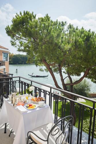 a table with food and a view of the water at Hotel Cipriani, A Belmond Hotel, Venice in Venice