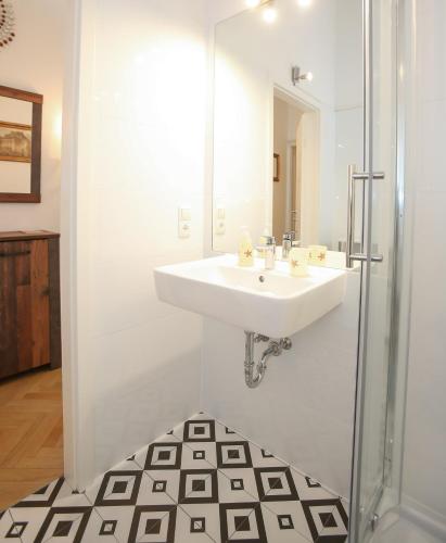 a white bathroom with a sink and a shower at Apartments Opera in Vienna
