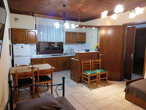 Loutrá ElevtherónにあるHoliday Home Sea Frontのキッチン(木製キャビネット、テーブル付)、ダイニングルームが備わります。