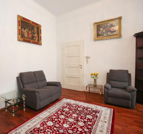 a living room with two chairs and a rug at Apartments Opera in Vienna
