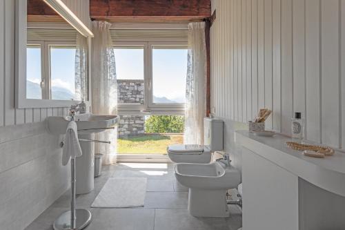 コーリコにあるVilla Meravigliaのバスルーム(トイレ2つ、洗面台、窓付)