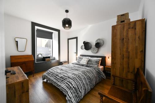 a bedroom with a bed and a wooden floor at South Shores Cottage Flat in Troon