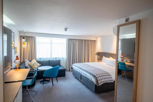 a hotel room with a bed and a desk at Holiday Inn - Leicester - Wigston by IHG in Leicester