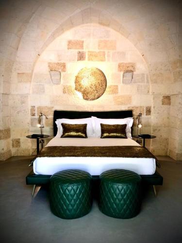 a bedroom with a bed with two ottomansigunigunigun at Masseria Li Reni in Manduria