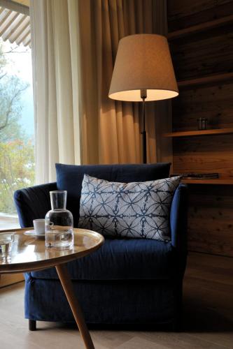 a living room with a blue couch and a table at Seehotel Enzian in Weissensee