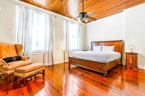 1 dormitorio con 1 cama y 1 silla en Hosteeva Huge 4-bedroom, 2-living room Condo in the Heart of New Orleans en Nueva Orleans