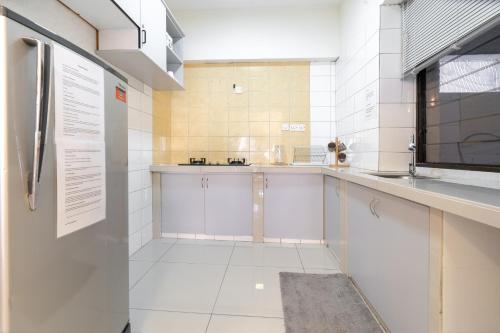 eine Küche mit weißen Schränken und einem großen Fenster in der Unterkunft DELUXE Suite Seaview Batu Ferringhi 2304 - 2 Rooms in Batu Feringgi