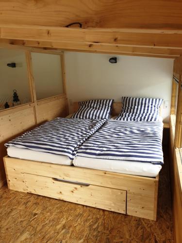 a bed with a wooden frame in a room at Beim Hooch. Lisbeth in Brücktal