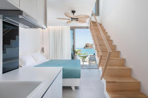 a room with a staircase leading up to a balcony at Vergina Beach Hotel in Agia Marina Nea Kydonias