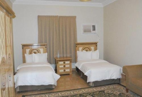 a hotel room with two beds and a couch at اصال حائل للوحدات السكنية المفروشة in Hail