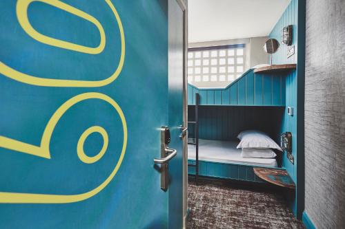 Cette chambre dispose d'un lit superposé avec un mur bleu et jaune. dans l'établissement Garrison Cells, à Fort William