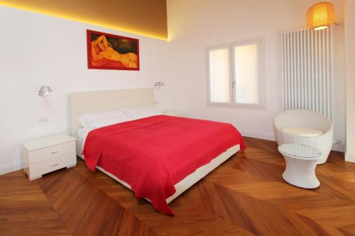 a bedroom with a bed with a red blanket at Casa Leonica in Torno