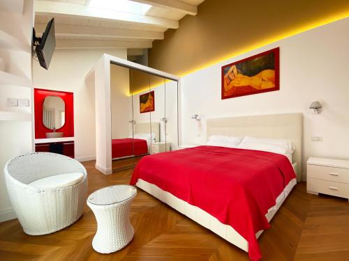 Un dormitorio con una gran cama roja y un espejo en Casa Leonica, en Torno