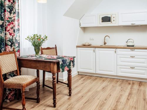 a kitchen with a table with a vase on it at Kaszubskie Zacisze in Władysławowo