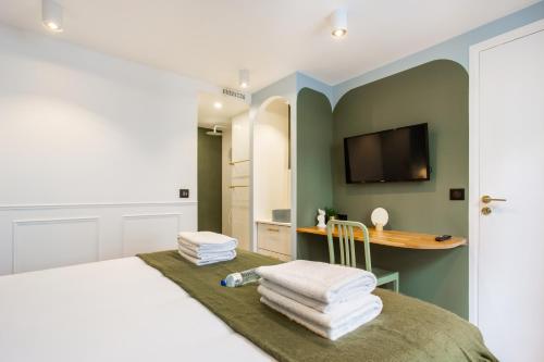 a bedroom with a bed and a desk and a television at CMG BHV Marais / Rue Vieille du Temple in Paris