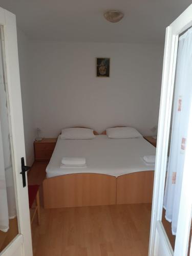 a small bedroom with a bed with a wooden floor at Apartman Matea in Hvar