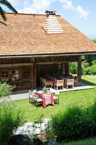 - un pavillon avec une table et des chaises en face d'une maison dans l'établissement Chalet Chatel, avec services, Collection Chalets des Fermes - Megève, à Megève