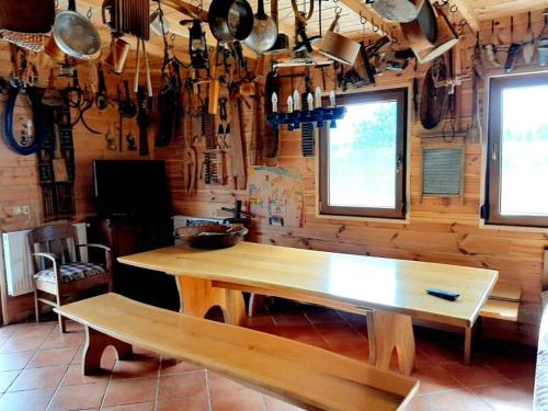 a kitchen with a wooden table and pots and pans at U Malwiny in Rajskie Sakowczyk
