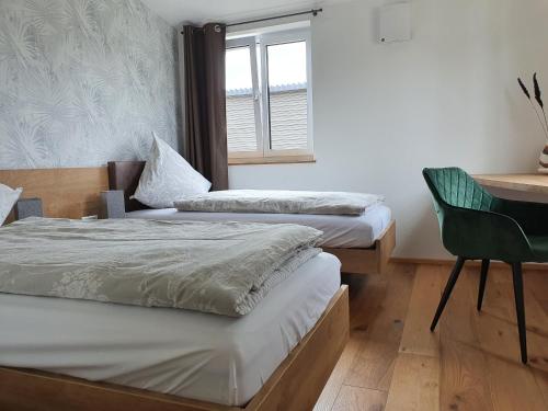 2 camas en una habitación con escritorio y silla en Ferienhaus am Funkenbühl en Salem