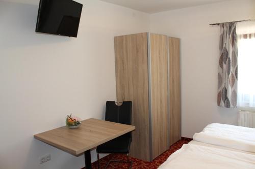 a room with a desk and a cabinet and a bed at Pension Steinbichler - Apartments und Zimmer Check in 24-7 in Graz