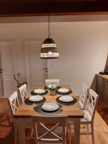 a dining room table with white chairs and a light fixture at Casa Nonna Tereza in Premantura